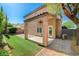 View of backyard with covered patio, artificial grass, brick pavers, and partial privacy wall at 5931 Allanche Ave, Las Vegas, NV 89141