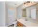 Bathroom features a wood vanity, decorative mirror, updated fixtures and window with shutters at 5931 Allanche Ave, Las Vegas, NV 89141