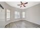 Spacious bedroom with wood-look floors, a ceiling fan, and an abundance of natural light from multiple windows at 5931 Allanche Ave, Las Vegas, NV 89141
