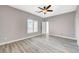 Empty bedroom featuring wood-look flooring, neutral paint, and natural light from a shuttered window at 5931 Allanche Ave, Las Vegas, NV 89141