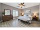 Staged bedroom with wood-look flooring, modern decor, and ample natural light, creating a cozy atmosphere at 5931 Allanche Ave, Las Vegas, NV 89141