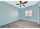 Light blue bedroom featuring a ceiling fan, window with blinds, and modern wood-look flooring at 5931 Allanche Ave, Las Vegas, NV 89141