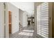 Inviting entryway featuring wood-look floors, shuttered windows, and a view of the staircase and open-concept living space at 5931 Allanche Ave, Las Vegas, NV 89141