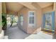 Inviting front porch with tiled flooring, large windows, and a beautiful blue front door at 5931 Allanche Ave, Las Vegas, NV 89141