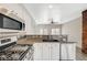Well-equipped kitchen with stainless steel appliances, granite countertops, white cabinets, and a stylish backsplash at 5931 Allanche Ave, Las Vegas, NV 89141