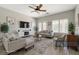 Staged living room featuring neutral tones, modern furniture, ceiling fan and natural light at 5931 Allanche Ave, Las Vegas, NV 89141