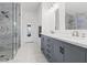 Modern bathroom featuring a glass shower and double vanity with stylish gray cabinets and marble countertops at 600 Beresford Ave, Las Vegas, NV 89123
