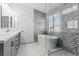 Modern bathroom featuring a soaking tub, glass shower, double vanity, and stylish tile accents at 600 Beresford Ave, Las Vegas, NV 89123