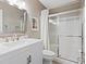 Bathroom featuring a single vanity with marble countertop and a glass-enclosed tub-shower combination at 600 Beresford Ave, Las Vegas, NV 89123
