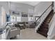 Spacious living room with high ceilings, large windows, staircase, and comfortable seating area at 600 Beresford Ave, Las Vegas, NV 89123