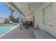 Covered patio with ceiling fans and outdoor seating next to a refreshing pool and well-maintained backyard at 600 Beresford Ave, Las Vegas, NV 89123