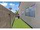 A clean and tidy side yard space featuring low maintenance turf and neutral paint at 600 Beresford Ave, Las Vegas, NV 89123