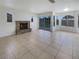 Bright living room with tile floors, stone fireplace, and sliding glass doors to the backyard at 6120 Desert Haven Rd, Las Vegas, NV 89130