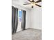Bright bedroom with a ceiling fan, light gray carpet, and window with gray drapes at 6581 Netherseal Ave, Las Vegas, NV 89139