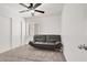 Bedroom with light gray carpet and a modern black futon positioned beneath a window and ceiling fan at 6581 Netherseal Ave, Las Vegas, NV 89139