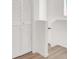 Neutral hallway featuring white floors, white walls, and white closet doors at 6581 Netherseal Ave, Las Vegas, NV 89139