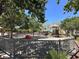 Community playground featuring slides, swings, and climbing structures in a fenced area surrounded by mature trees at 6581 Netherseal Ave, Las Vegas, NV 89139