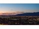 Aerial view of the city lights under a twilight sky, with mountains silhouetted in the distance at 700 W Carson Ave # 2307, Las Vegas, NV 89106