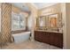 Elegant bathroom featuring a freestanding tub, double vanity, and decorative chandelier at 7206 Laramie Ave, Las Vegas, NV 89113
