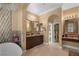 Bright bathroom with double sinks, an archway, and walk-in closet access at 7206 Laramie Ave, Las Vegas, NV 89113