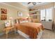 Cozy bedroom with neutral tones, decorative shelves and a comfortable bed with white and orange accents at 7206 Laramie Ave, Las Vegas, NV 89113