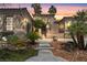 Inviting home featuring desert landscaping and palm trees against a colorful sunset sky at 7206 Laramie Ave, Las Vegas, NV 89113
