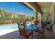 Covered patio boasts outdoor seating with a view of the pool, spa, and landscaped backyard at 7206 Laramie Ave, Las Vegas, NV 89113