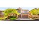 Charming two-story home featuring a paved driveway, manicured landscaping, and a two-car garage at 749 Middle Beach St, Las Vegas, NV 89138