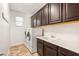 Spacious laundry room featuring a washer, dryer, sink and ample cabinet space for storage at 749 Middle Beach St, Las Vegas, NV 89138
