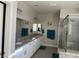 Bright bathroom featuring a double sink, granite countertops, and a glass-enclosed shower at 7855 Skyler Falls Ln, North Las Vegas, NV 89084