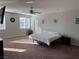 Large, sunlit bedroom featuring a ceiling fan, neutral paint, and carpet flooring at 7855 Skyler Falls Ln, North Las Vegas, NV 89084