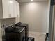 Laundry room with white cabinets and dark modern appliances at 7855 Skyler Falls Ln, North Las Vegas, NV 89084