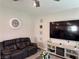 Comfortable living room with tile flooring, recessed lighting, and a large flat screen television at 7855 Skyler Falls Ln, North Las Vegas, NV 89084