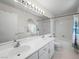 Bathroom featuring double sink vanity with large mirror and a shower-tub combo at 8733 Country Pines Ave, Las Vegas, NV 89129