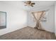 Bright bedroom with neutral carpet, a ceiling fan, and a window with curtains for privacy at 8733 Country Pines Ave, Las Vegas, NV 89129