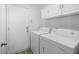 Bright laundry room features a white washer and dryer, along with white cabinets above at 8733 Country Pines Ave, Las Vegas, NV 89129