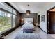 Modern bedroom with a tufted headboard, stylish lighting, and large windows offering ample natural light at 8925 W Flamingo Rd # 117, Las Vegas, NV 89147