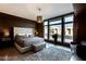 Stylish bedroom with a tufted headboard, plush rug, and large windows providing natural light and views at 8925 W Flamingo Rd # 117, Las Vegas, NV 89147