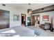 Bright bedroom featuring a modern light fixture, comfortable seating, and ensuite bath entrance at 8925 W Flamingo Rd # 117, Las Vegas, NV 89147