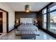 Modern bedroom with large windows, tufted headboard, and a pendant light fixture illuminating the space at 8925 W Flamingo Rd # 117, Las Vegas, NV 89147