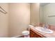 Cozy bathroom featuring a toilet, sink with wooden cabinets, light fixtures, and beige walls at 9073 Spoonbill Ridge Pl, Las Vegas, NV 89143