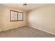 Beige bedroom featuring carpet, tan walls and a large window with wooden shutters at 9073 Spoonbill Ridge Pl, Las Vegas, NV 89143