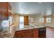 Well-lit kitchen featuring a double sink, granite countertops, and wooden cabinets and shuttered window coverings at 9073 Spoonbill Ridge Pl, Las Vegas, NV 89143