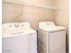 Laundry room featuring a white washer and dryer with overhead shelving at 9073 Spoonbill Ridge Pl, Las Vegas, NV 89143