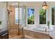 Luxurious bathroom features a glass-enclosed shower, soaking tub, and large windows for natural light at 1 Via Mira Monte, Henderson, NV 89011