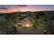 Stunning exterior view of a desert home with lush palm trees and a beautiful sunset sky at 1 Via Mira Monte, Henderson, NV 89011