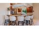Kitchen bar area with marble countertops, dark wood cabinetry, and seating for five at 1 Via Mira Monte, Henderson, NV 89011