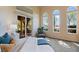 Bright main bedroom featuring arched windows, comfortable chair and a door to the outside at 1 Via Mira Monte, Henderson, NV 89011