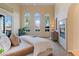Bright main bedroom featuring a cozy fireplace, arched windows, and a door to the outside at 1 Via Mira Monte, Henderson, NV 89011