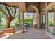 An elegant outdoor patio features a stone floor, dining table, spiral columns, and a lush, green landscape at 1 Via Mira Monte, Henderson, NV 89011